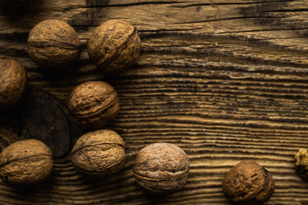 Walnut scattered on the wooden vintage table. Walnuts is a healthy vegetarian protein nutritious food. Walnut on rustic old wood. - Foto, Imagem