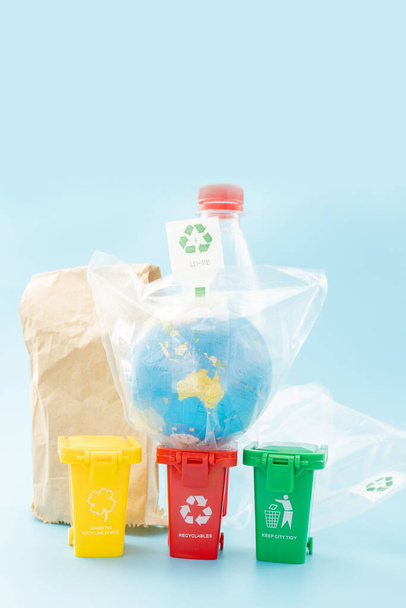 Yellow, green and red recycle bins with recycle symbol on blue background. Keep city tidy, Leaves the recycling symbol. Nature protection concept. - 写真・画像