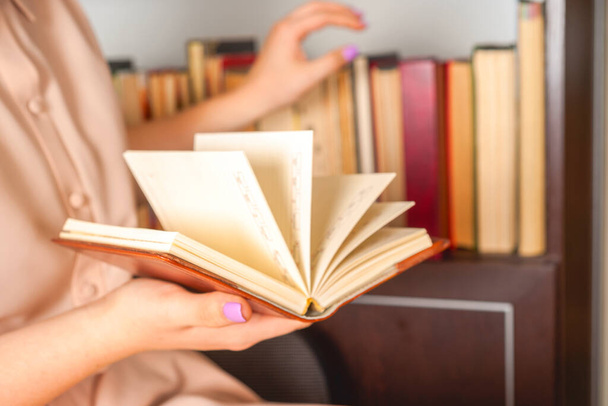 軽いドレスの少女が本を読んでいる。女の手は本を手に持っている - 写真・画像