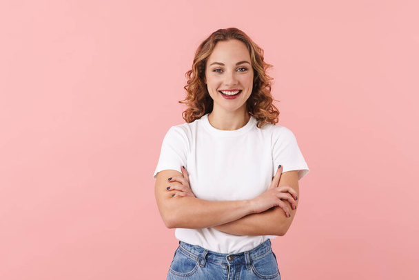 Image of a happy young pretty woman posing isolated over pink wall background. - Фото, изображение