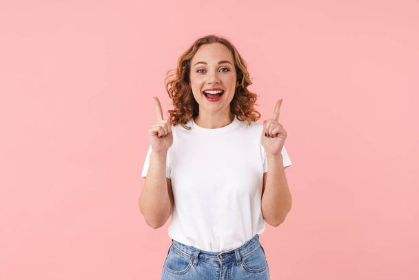 Image of a positive emotional young pretty woman posing isolated over pink wall background pointing. - Foto, Bild