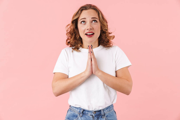 Photo of a cute young pretty woman posing isolated over pink wall background make please pray gesture. - Фото, зображення