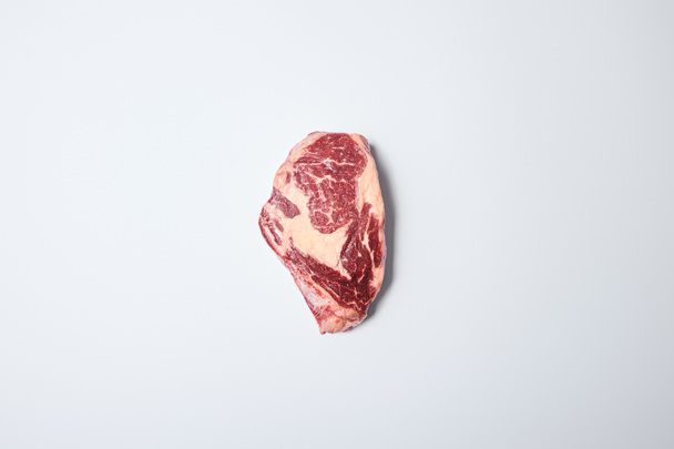 top view of fresh raw steak on on white background - Fotó, kép