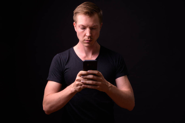 Portrait of young handsome man using phone - Foto, imagen
