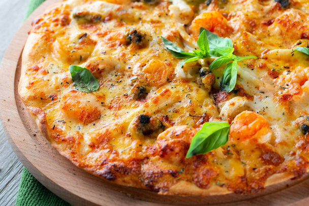 Meeresfrüchte dünne leckere Pizza mit Garnelen, Muscheln und Basilikum auf hölzernem Hintergrund - Foto, Bild