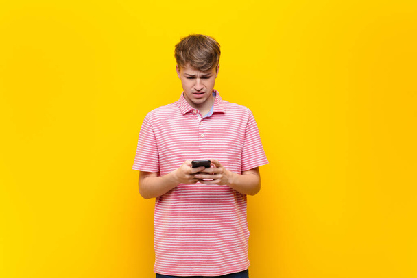 young blonde man with a smartphone mobile - Fotó, kép