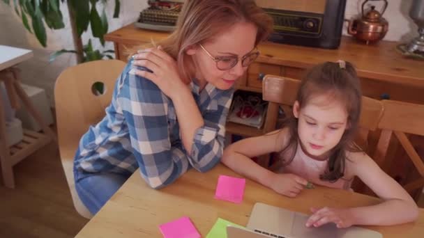 child learns online and mother works remotely during quarantine - Materiał filmowy, wideo