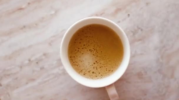 Πρωινή κούπα καφέ με γάλα σε μαρμάρινο τραπέζι - Πλάνα, βίντεο