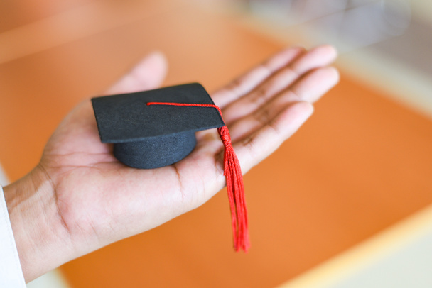 Εκπαίδευση Αποφοίτησης Business Study Concept / Επιχειρηματίας ή φοιτητής με καπέλο αποφοίτησης στο χέρι σε καθημερινή αποφοίτηση συνεχάρη τους αποφοίτους στη βιβλιοθήκη του Πανεπιστημίου - Φωτογραφία, εικόνα
