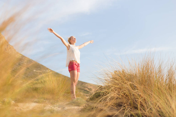 Свободная счастливая женщина, наслаждающаяся солнцем на каникулах
. - Фото, изображение