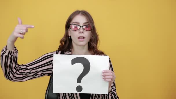 Verwirrtes Mädchen hält Blatt Weißbuch mit Fragezeichen in der Hand - Filmmaterial, Video