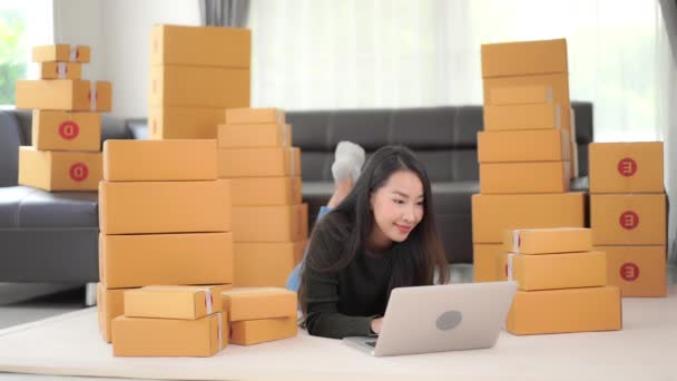 箱の中の小包で家で働いている美しいアジアの女性の映像 - 映像、動画