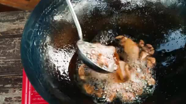 Cocinar en olla wok. Un chef cocinando pescado frito en una olla wok. Primer plano de freír pescado en la freidora en aceite caliente
. - Imágenes, Vídeo