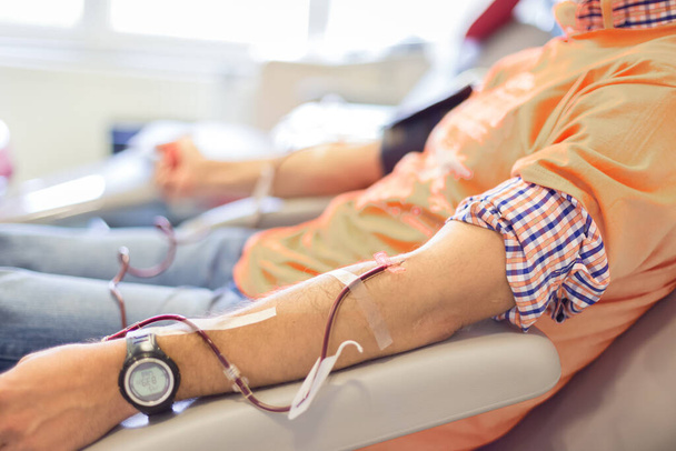 Doador de sangue em doação com uma bola saltitante segurando na mão
 - Foto, Imagem