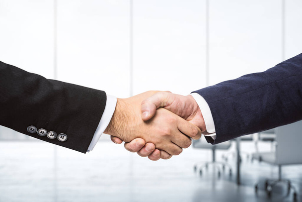 Handshake of two businessmen on the background of bright boardroom, partnership concept, close up - Fotoğraf, Görsel