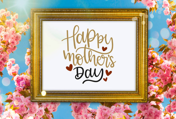Χαρούμενη κάρτα χαιρετισμού της μητέρας με φόντο το γαλάζιο του ουρανού, ροζ άνθη κερασιάς, ηλιαχτίδες και boke - Φωτογραφία, εικόνα