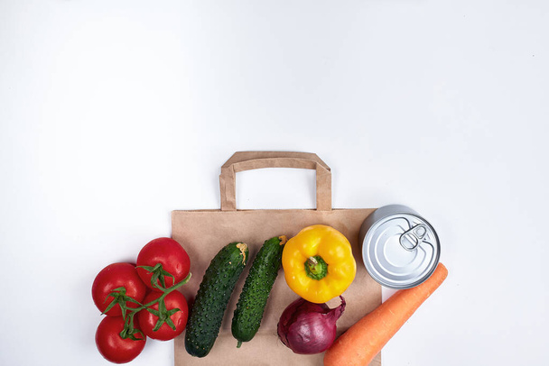 Food for quarantine. Fruits, vegetables, canned food, cereal swells with a paper bag. Copyspace. On a white background - 写真・画像