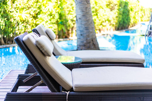 Prázdná židle paluba salonek kolem bazénu v hotelovém resortu pro cestovní dovolenou - Fotografie, Obrázek