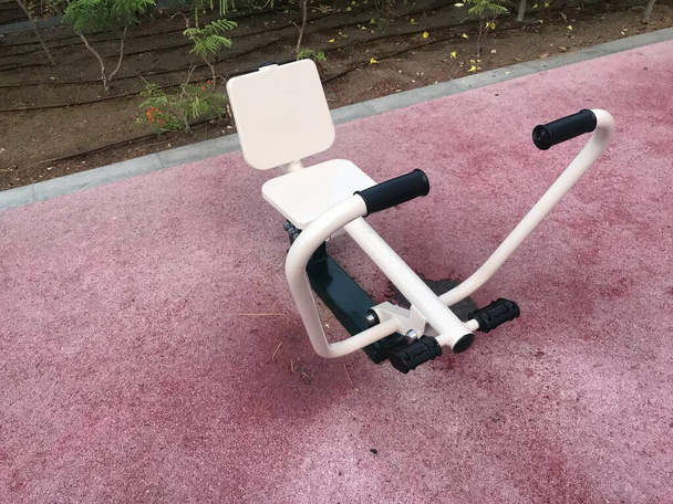 Χειρωνακτικός εξοπλισμός γυμναστηρίου στερεωμένος γύρω από το ελαστικό δάπεδο για σωματική άσκηση και άσκηση για τη διατήρηση υγιούς σώματος - Φωτογραφία, εικόνα