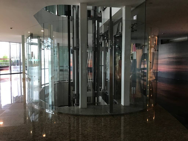 Ascensores de pasajeros o ascensores en forma circular cubiertos por tabiques de vidrio templado para consumidores o usuarios
 - Foto, Imagen