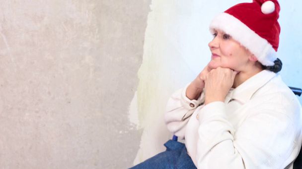 Vanhempi nainen, jolla on jouluhattu pyörätuolissa
 - Materiaali, video