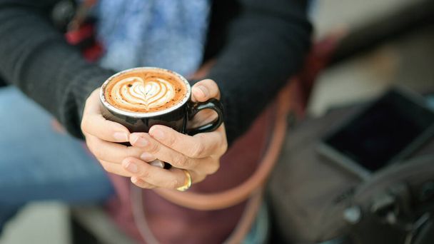 Coffee latte heart texture in hand of tourists. - Fotografie, Obrázek