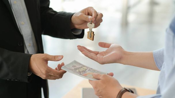 Zákazníci a pronajímatelé si po domluvě na koupi domu vyměňují peníze a klíče. - Fotografie, Obrázek
