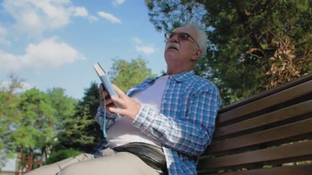 Starší muž si přečetl knihu a zastavil se, aby si promluvil se svými vnoučaty - Záběry, video