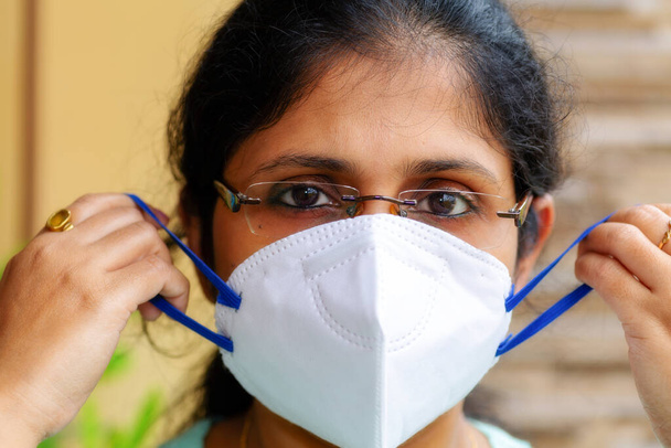 Indian woman in close up view wearing an n95 face mask for corona virus awareness concept - Фото, изображение