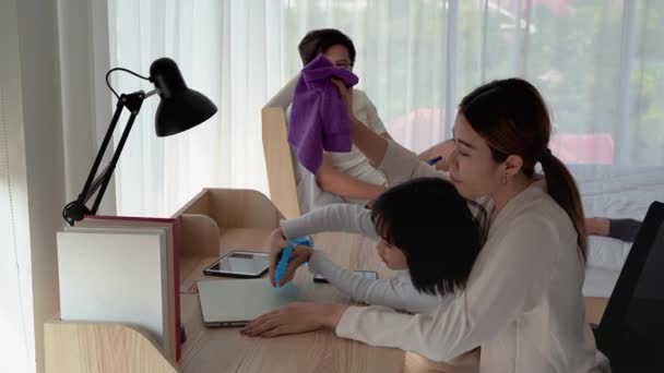 Mother is teaching her daughter to use the spray to clean various devices. Inside the house to be free from germs - Imágenes, Vídeo