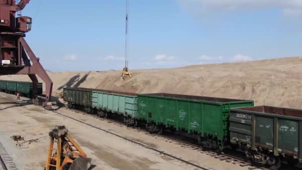 załadunek piasku do wagonów kolejowych z pomocą koparki kariery - Materiał filmowy, wideo