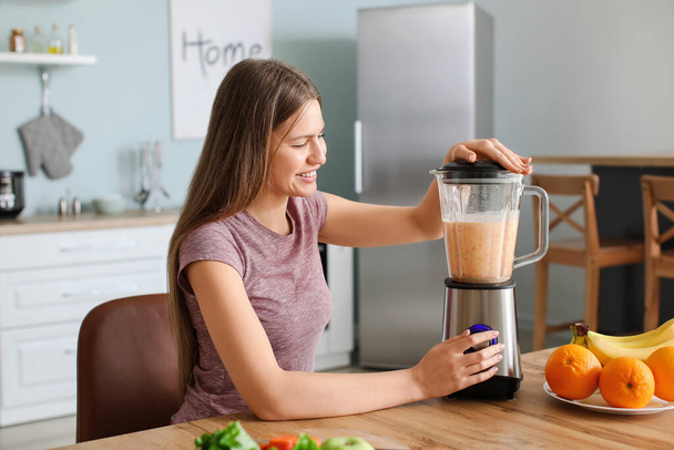Fiatal nő csinál smoothie a konyhában otthon - Fotó, kép