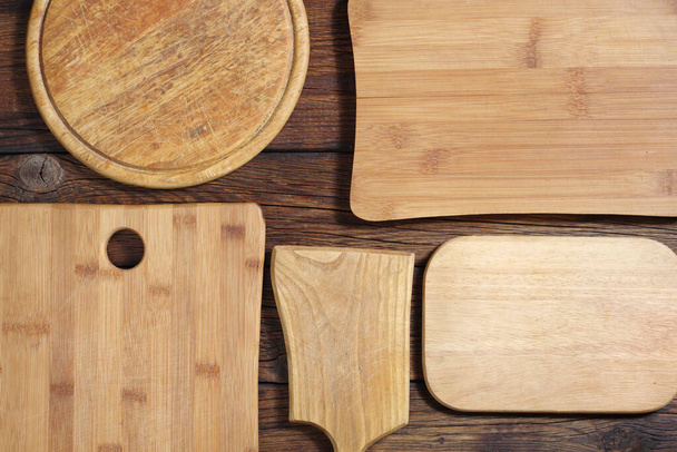 Various cutting board on wooden background, top view - Zdjęcie, obraz