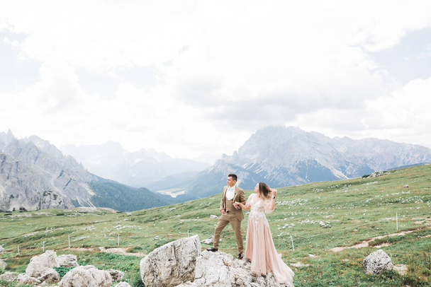 Beautiful gorgeous bride posing to groom and having fun near at mountains with amazing view, space for text, wedding couple - Fotoğraf, Görsel