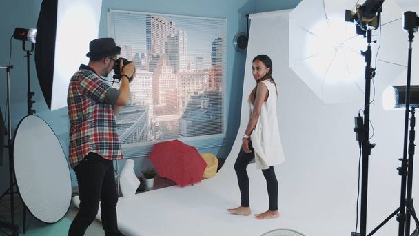 Kaunis sekarotuinen tyttö poseeraa valokuvaaja ammatillinen studio valokuva ampua
 - Valokuva, kuva