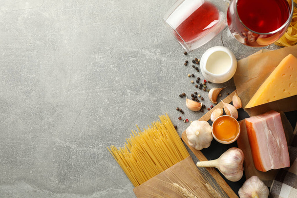 Koostumus pastaa ja ainesosia ruoanlaittoon harmaalla pohjalla
 - Valokuva, kuva