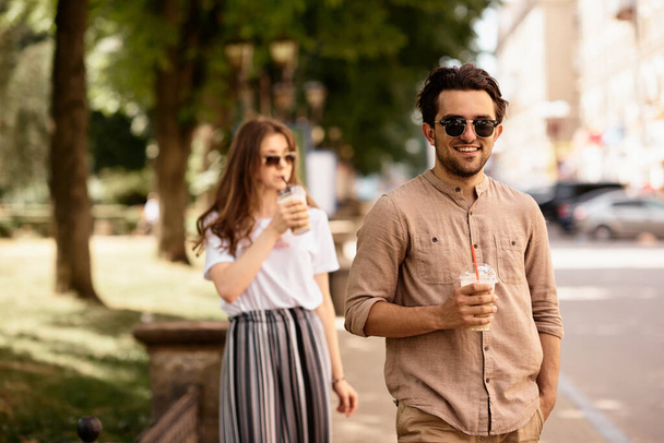 young beautiful couple have a fun and walking on city streets and drinking coffee - Zdjęcie, obraz