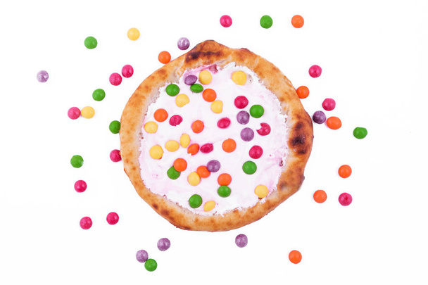 Słodka pizza z sosem piankowym i kolorowe słodycze na białym tle. Zdjęcie poziome - Zdjęcie, obraz