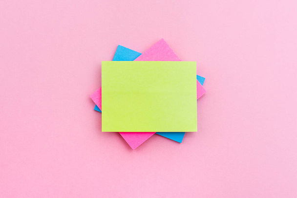 Sticky of different colors on the pink surface. Stationery. - Photo, image