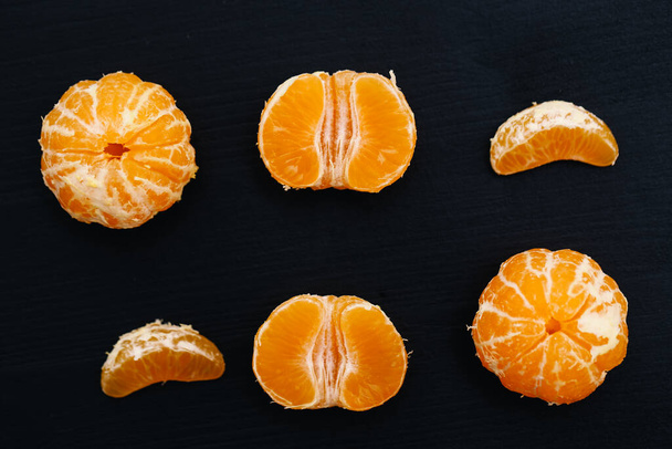 Shelled mandarins on a black background - Valokuva, kuva