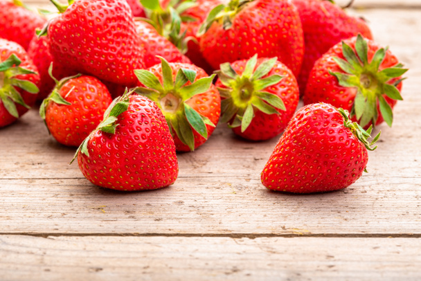 Strawberries on a wooden surface background - Photo, Image