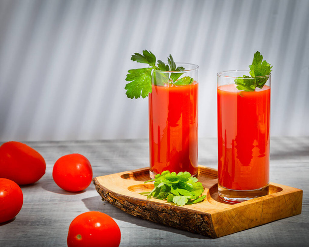 Tomatensaft und frische Tomaten auf hölzernem Hintergrund - Foto, Bild