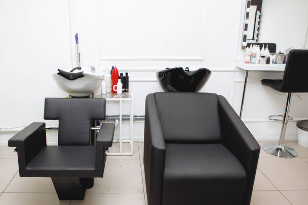 Salón de belleza interior. Gamma en blanco y negro. Silla y fregadero para lavarse el cabello
. - Foto, Imagen