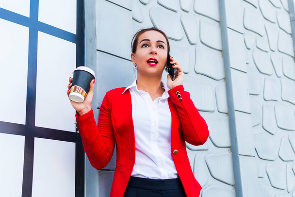 business woman holding coffee and talking on the phone - Photo, Image