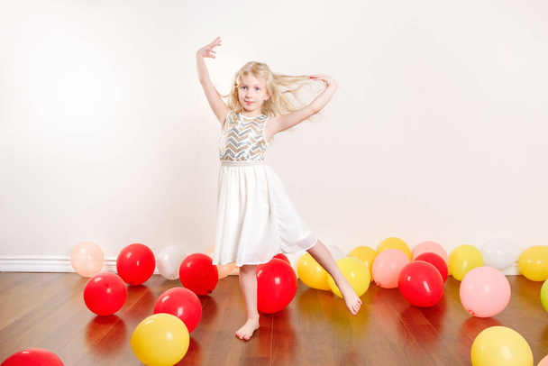 Nettes entzückendes kleines Mädchen, das zu Hause Geburtstag feiert. Schöne Mädchen Kind mit bunten Luftballons Spaß haben. Quarantäne-Geburtstagsparty allein zu Hause während der Selbstisolation der COVID-19-Pandemie. - Foto, Bild