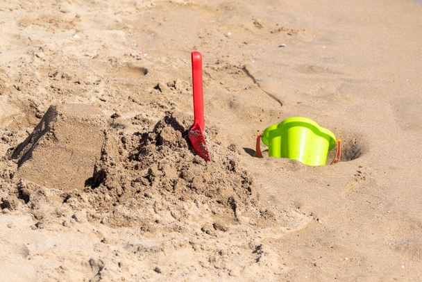 Яркие пластиковые детские игрушки в песке. Концепция пляжного отдыха для детей
. - Фото, изображение