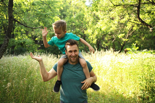 幸せな愛情の父と息子の演奏と抱擁。家族の散歩だ。夏時間一緒に、太陽の光。幸せな父の日. - 写真・画像