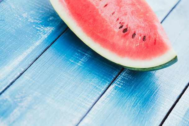 Fresh watermelon slice on blue wooden  background. Summer background - Foto, imagen
