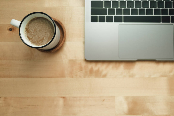 Робочий простір з ноутбуком і чашкою кави на дерев'яному столі
. - Фото, зображення