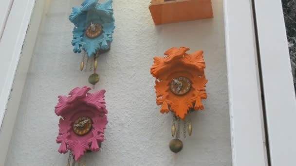 Разноцветные настенные часы с маятником в окне часового магазина
 - Кадры, видео